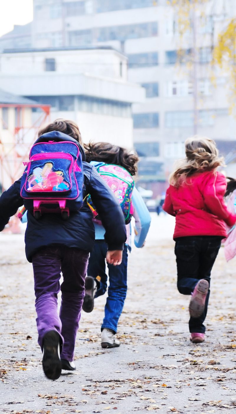 happy school girls running outdoor at sunny autumn day